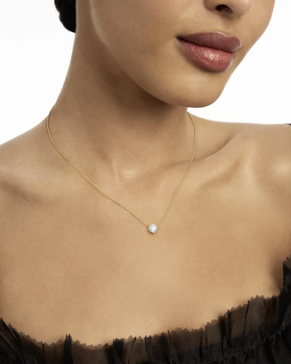Anhänger Atelier Wempe 137 von Wempe mit Diamant an einer feinen Gelbgoldkette, getragen